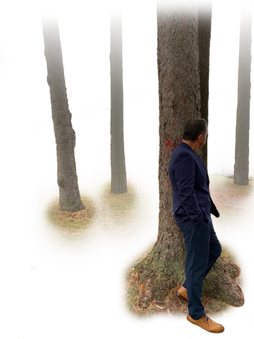 Robert Koziel leaning against a tree in a misty forest