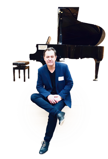 Robert Koziel seated in front of a grand piano